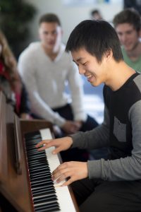 Student playing the piano in student lounge