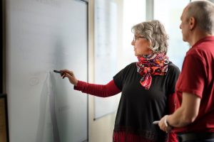30+ student writes on board